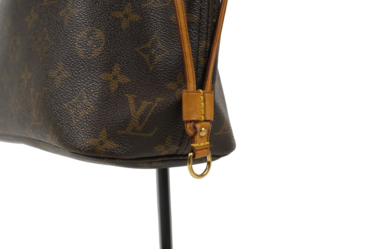 Interior of the Louis Vuitton Neverfull PM tote with branded lining and inner pocket