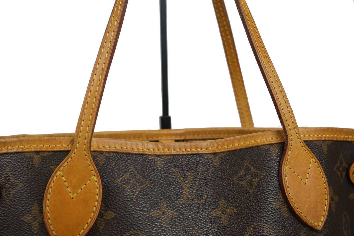 Close-up of gold-tone hardware and leather trim on the Louis Vuitton Neverfull PM