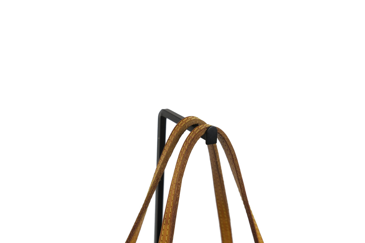 Close-up of the side leather trim and hardware on a brown Louis Vuitton Neverfull PM