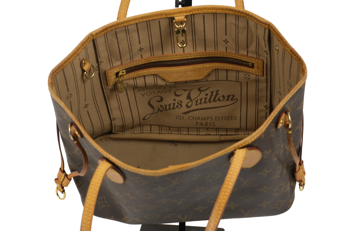 Angled view of the Louis Vuitton Neverfull PM tote with tan leather straps