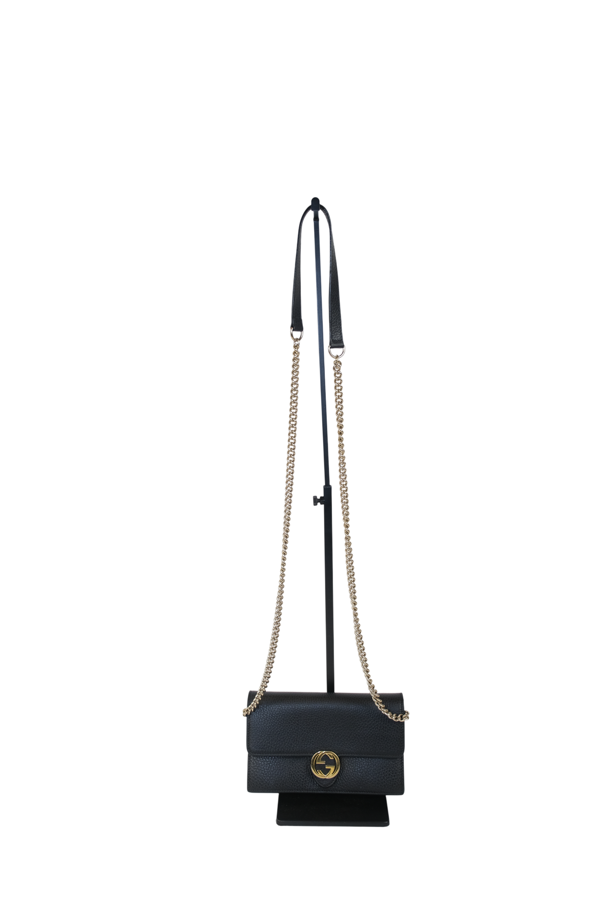 Black Gucci Interlocking G chain wallet shown with its gold-tone chain strap