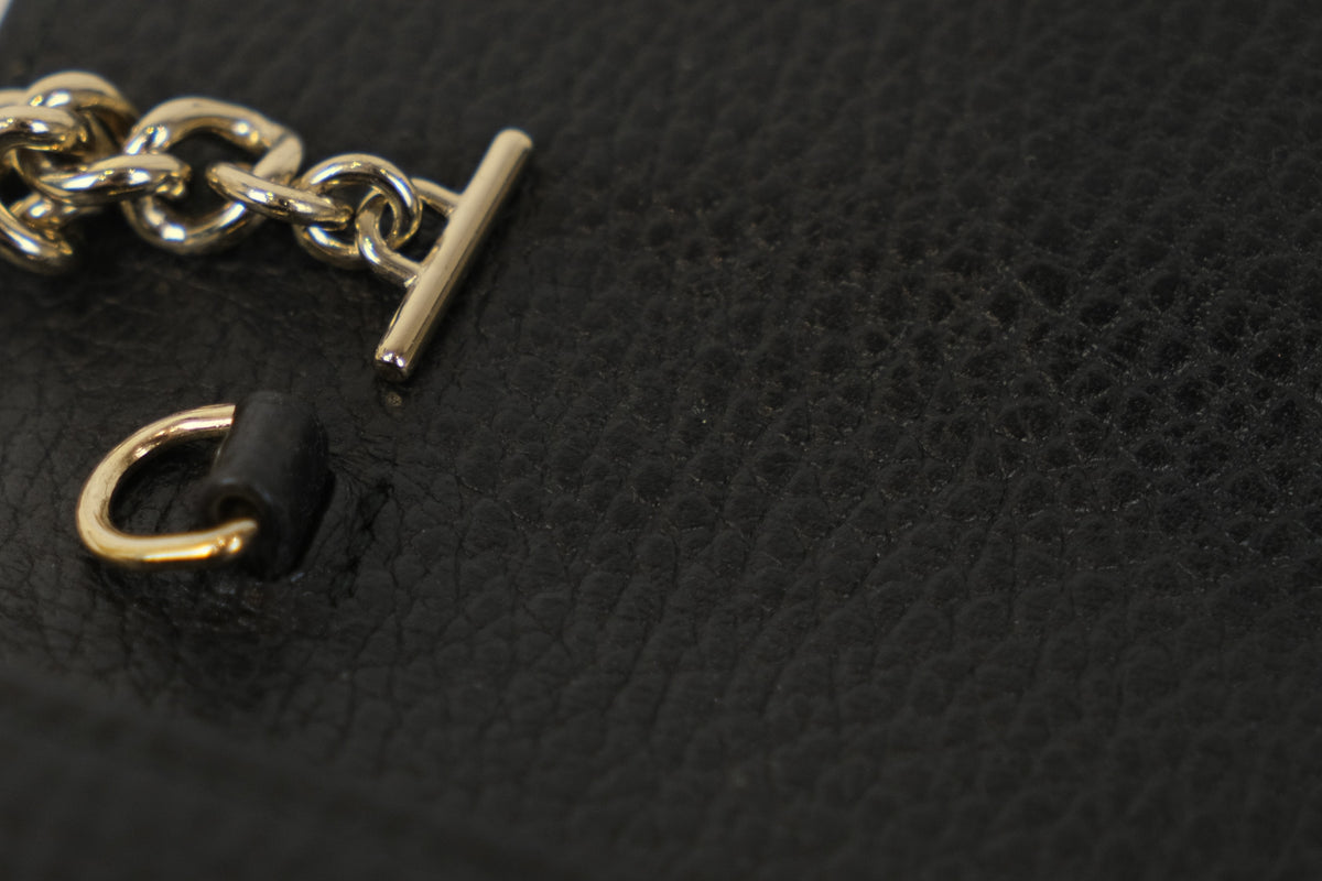Close-up of the gold-tone chain and leather shoulder pad on the Gucci chain wallet